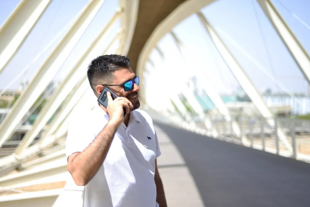 אייל מדר עומד על גשר ומדבר בטלפון